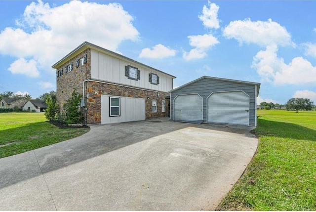 view of front of property with a garage, an outdoor structure, and a front yard