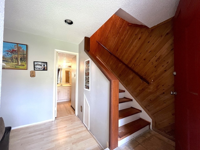 staircase featuring hardwood / wood-style floors and a textured ceiling