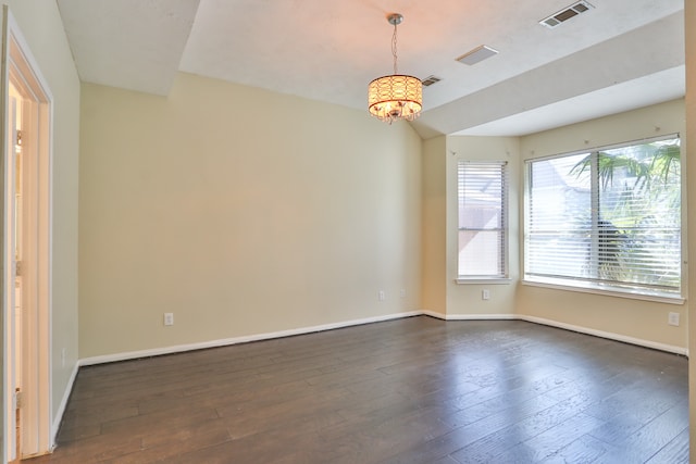 unfurnished room with dark hardwood / wood-style floors and a chandelier