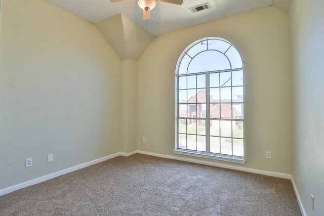 empty room with ceiling fan, carpet flooring, vaulted ceiling, and a wealth of natural light