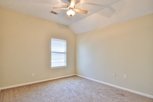 empty room featuring lofted ceiling, light colored carpet, and ceiling fan