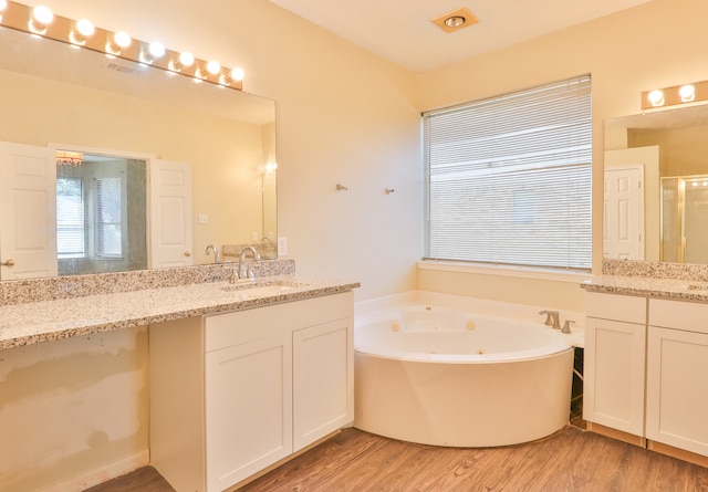 bathroom with vanity, independent shower and bath, and wood-type flooring