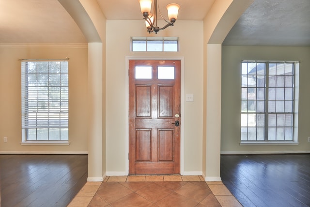 entryway featuring crown molding, a healthy amount of sunlight, and wood-type flooring