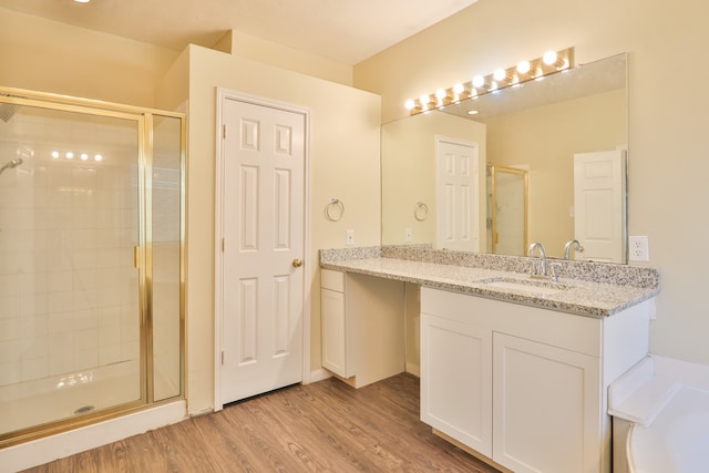 bathroom featuring vanity, hardwood / wood-style floors, and a shower with shower door