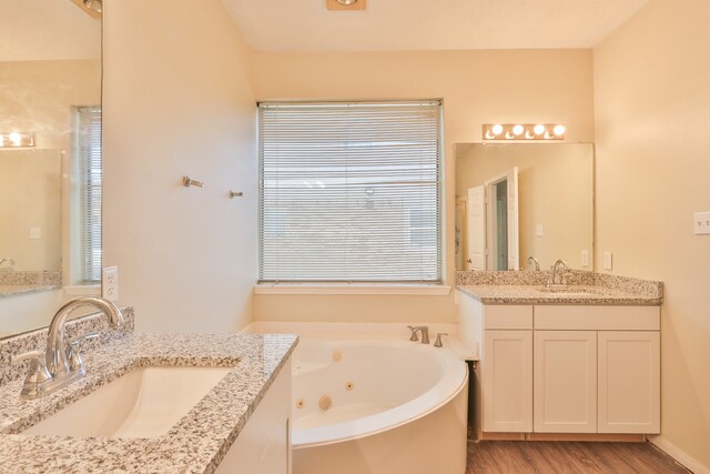 bathroom with vanity, hardwood / wood-style floors, and a bathtub