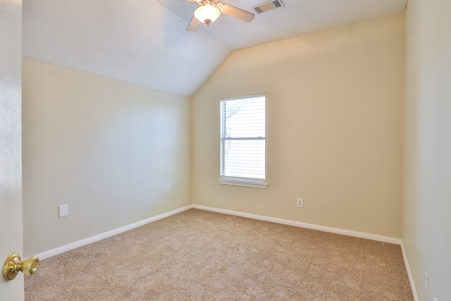 empty room featuring light carpet, ceiling fan, and vaulted ceiling