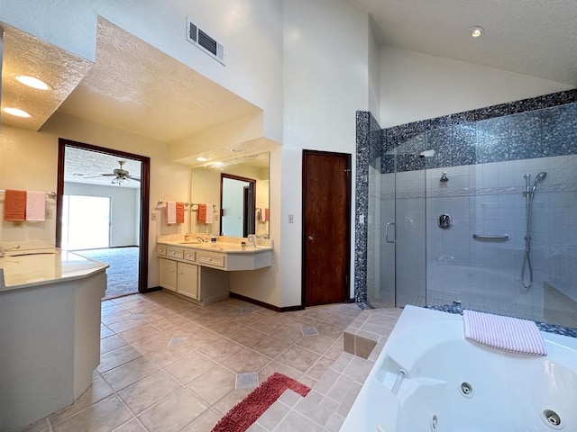 bathroom with ceiling fan, tile patterned floors, separate shower and tub, a textured ceiling, and vanity