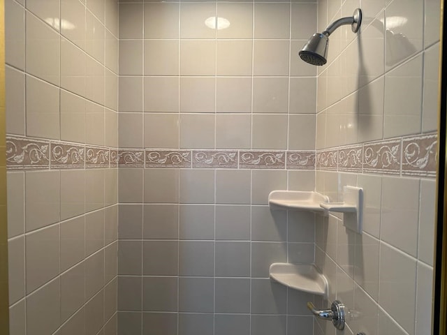 bathroom with a tile shower and tile walls