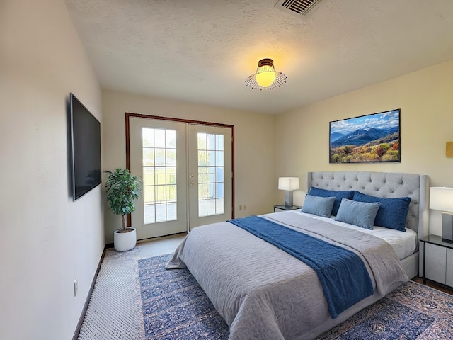 carpeted bedroom with a textured ceiling and access to outside