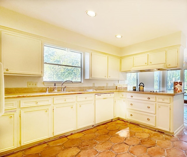 kitchen with white dishwasher, kitchen peninsula, sink, and black cooktop