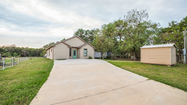 view of front of home with a shed and a front yard