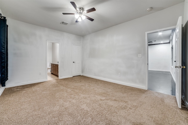 unfurnished bedroom with light colored carpet, ceiling fan, and connected bathroom