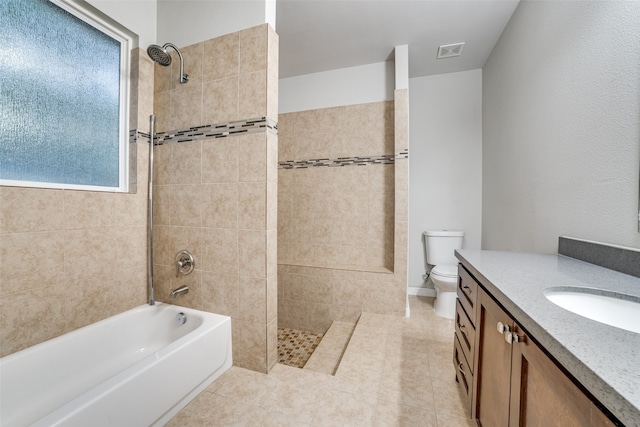 full bathroom featuring tiled shower / bath combo, vanity, tile patterned floors, and toilet