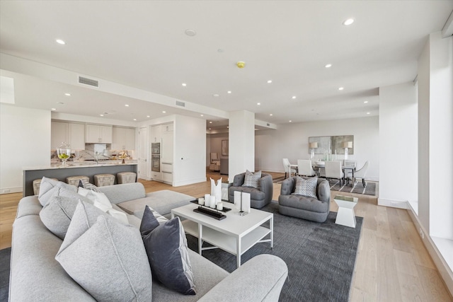 living room featuring visible vents, recessed lighting, light wood-style floors, and baseboards
