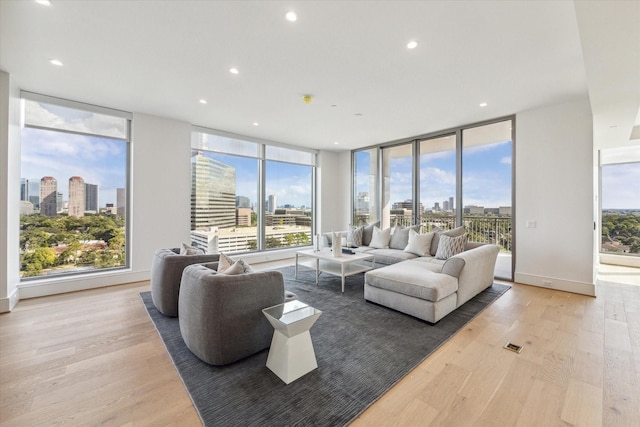 living room featuring recessed lighting, a city view, and light wood finished floors