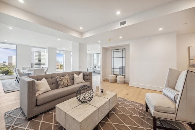 living room with recessed lighting, wood finished floors, and visible vents