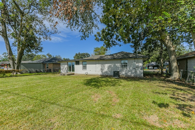 back of property featuring a yard and central AC unit