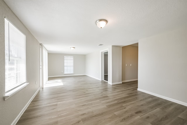 empty room featuring a textured ceiling and wood-type flooring