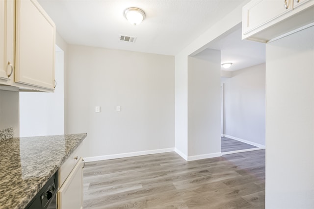 kitchen featuring white cabinetry, light stone counters, and light hardwood / wood-style floors