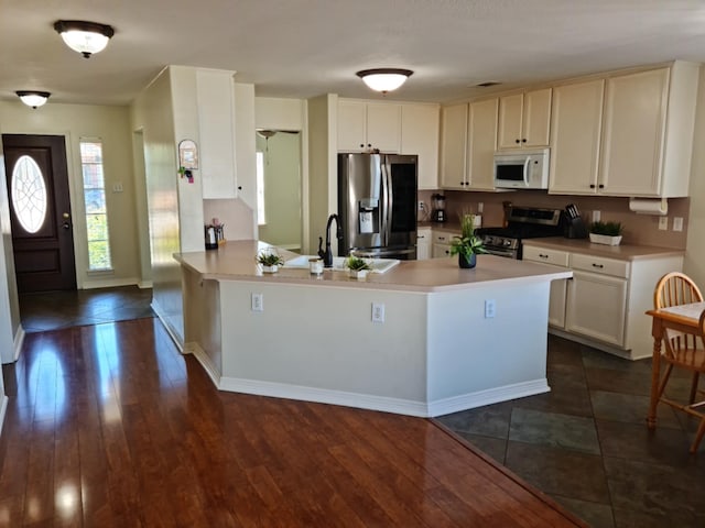 19626 Tularosa Ln, Tomball, TX 77377 - kitchen featuring appliances with stainless steel finishes, a sink, a peninsula, light countertops, and dark wood finished floors