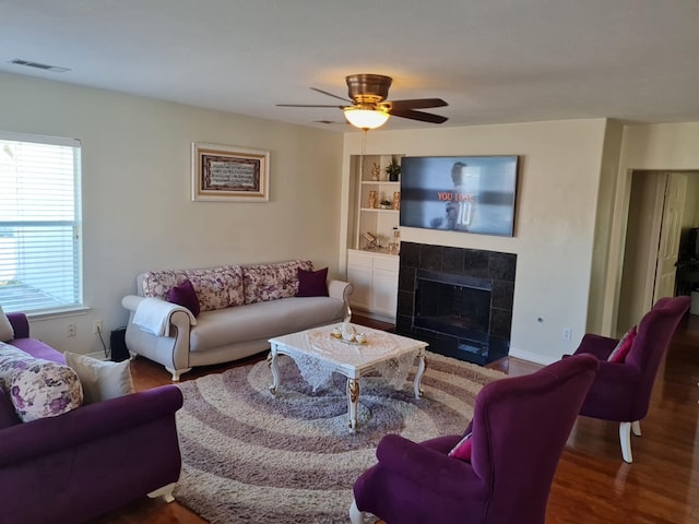 19626 Tularosa Ln, Tomball, TX 77377 - living area with wood finished floors, a fireplace, built in shelves, and a ceiling fan
