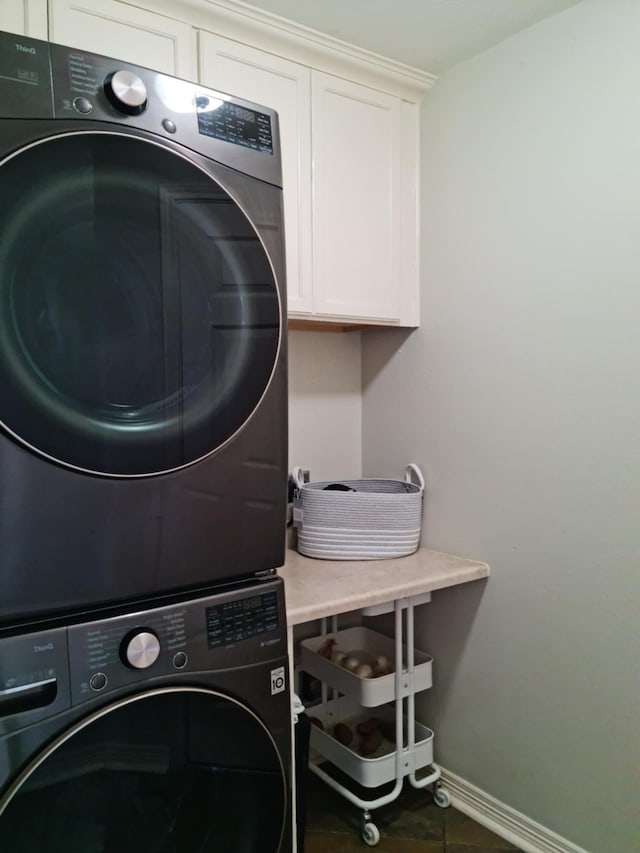 19626 Tularosa Ln, Tomball, TX 77377 - laundry area featuring stacked washer / dryer, cabinet space, and baseboards
