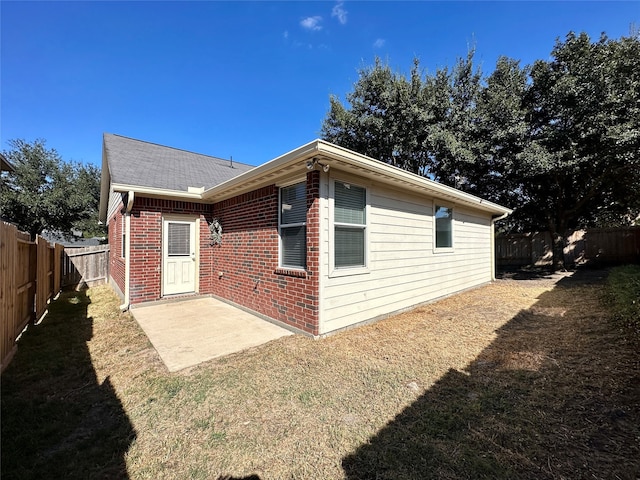 rear view of property featuring a patio and a lawn