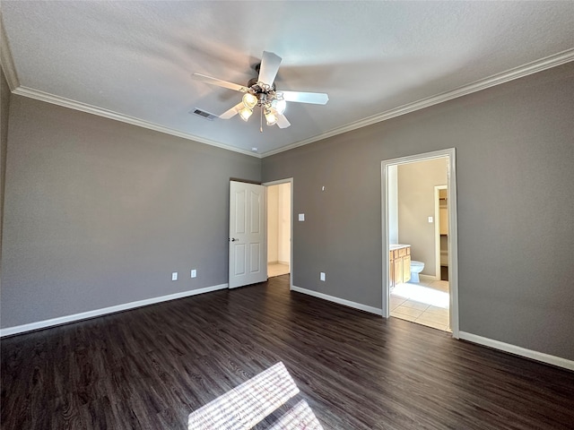 unfurnished bedroom with ceiling fan, crown molding, ensuite bathroom, and dark hardwood / wood-style floors