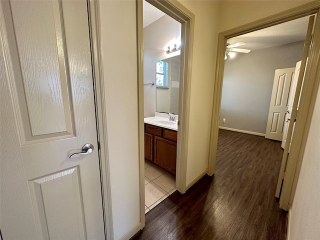 hall with sink and dark wood-type flooring