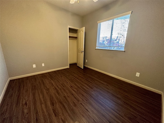 unfurnished bedroom with ceiling fan and dark hardwood / wood-style flooring