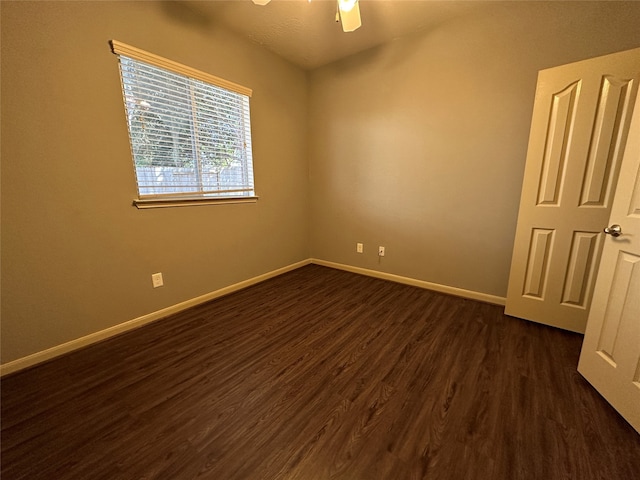 empty room with dark hardwood / wood-style floors and ceiling fan