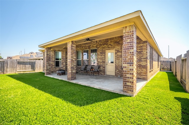 rear view of property featuring a patio, a yard, and ceiling fan