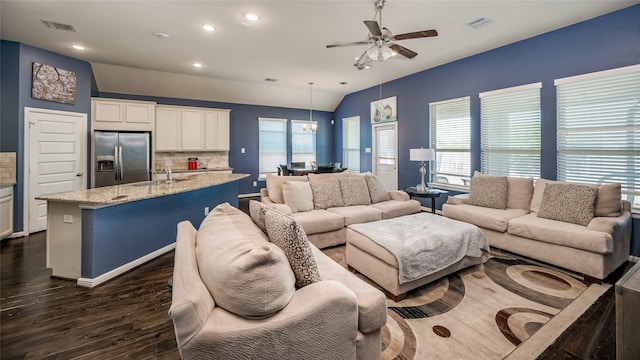 living room featuring dark hardwood / wood-style flooring, sink, plenty of natural light, and vaulted ceiling