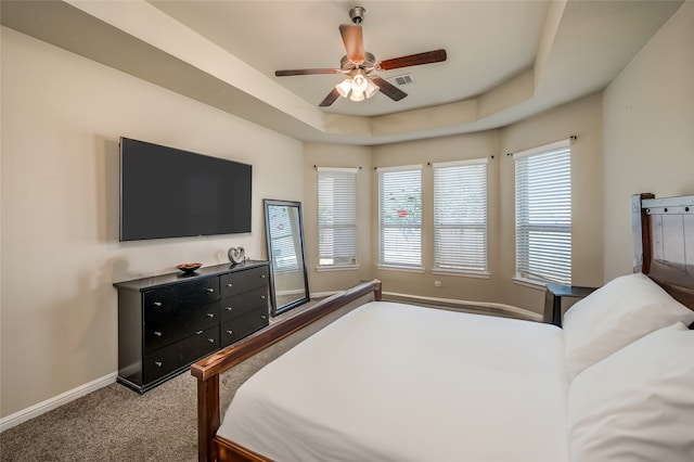 bedroom featuring carpet floors, a raised ceiling, and ceiling fan