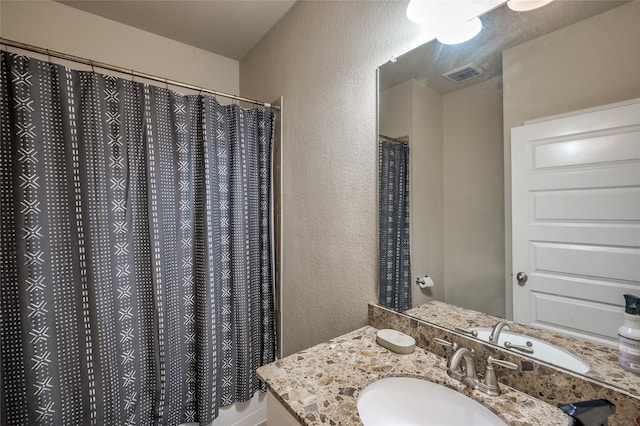 bathroom featuring vanity and a shower with shower curtain