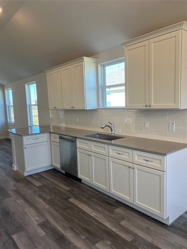 kitchen with white cabinets, stainless steel dishwasher, sink, and dark hardwood / wood-style floors