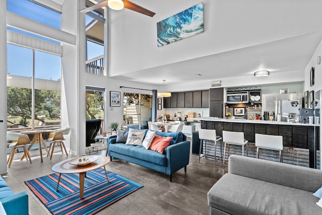 living room with a towering ceiling and ceiling fan