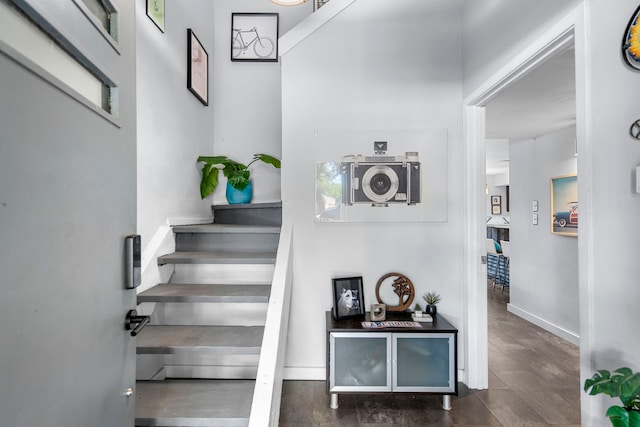 stairs featuring wood finished floors and baseboards