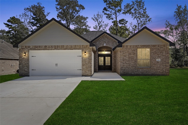 view of front of property with a yard, french doors, and a garage