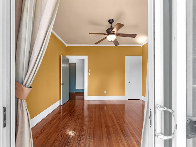 empty room featuring hardwood / wood-style flooring, ceiling fan, and crown molding