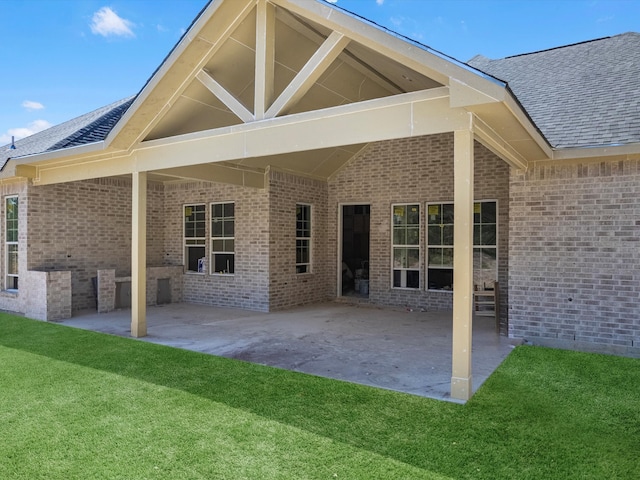 back of property featuring a lawn and a patio