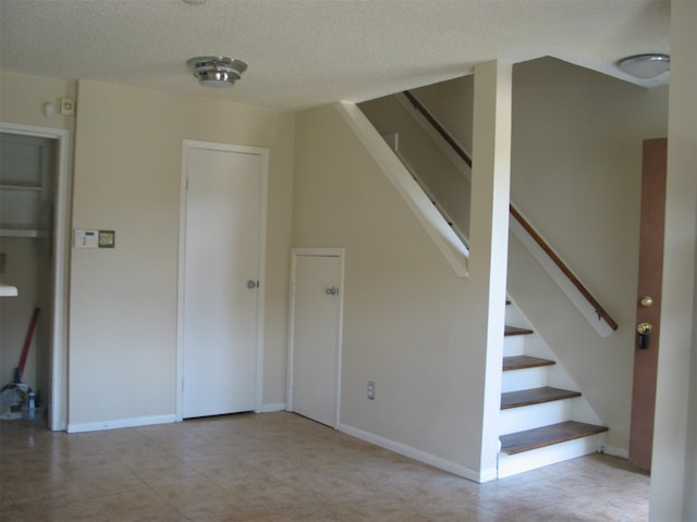 stairway featuring a textured ceiling