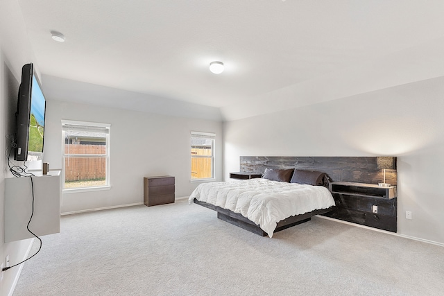 bedroom with light carpet and lofted ceiling