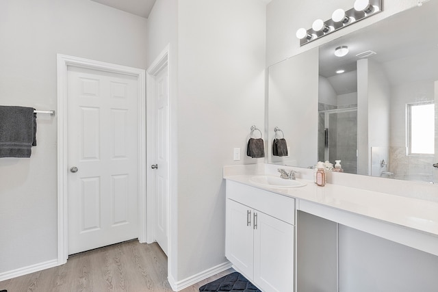 bathroom with vanity, wood-type flooring, and walk in shower