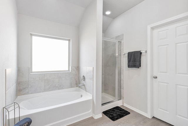 bathroom with lofted ceiling, hardwood / wood-style floors, and plus walk in shower