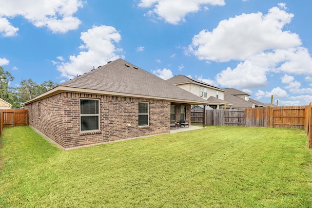 back of property with a patio area and a lawn