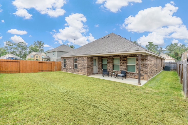 back of property with a patio, a yard, and central AC unit