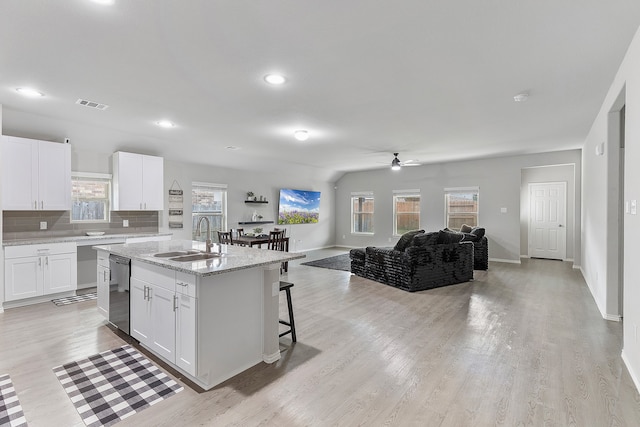 kitchen featuring white cabinetry, sink, a wealth of natural light, and a center island with sink