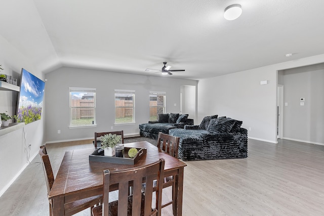 dining space featuring ceiling fan, lofted ceiling, and light wood-type flooring