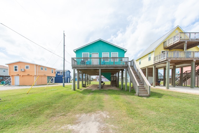 back of property with a wooden deck, a yard, a garage, and a carport